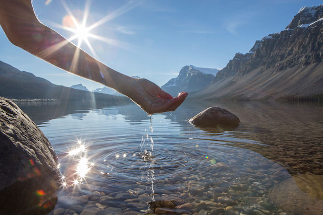 Woman touching water in natural lake