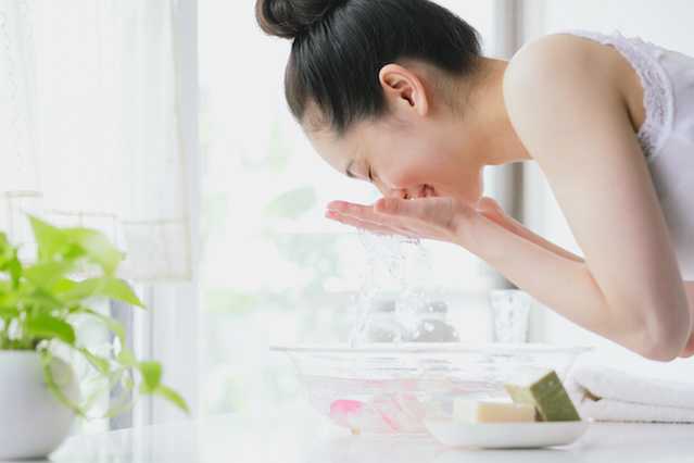 Femme aspergeant son visage d'eau après avoir utilisé un produit NEUTROGENA® pour peau sensible