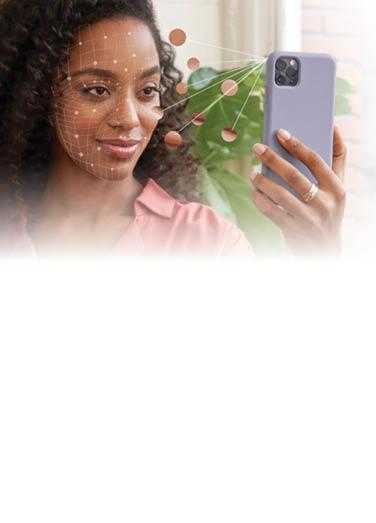 Femme qui tient un téléphone devant son visage pour utiliser l’application Neutrogena Peau360